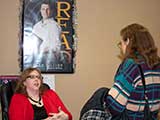 Debb chats with Linda Zaruches underneath the gaze of a holiday bedecked Nathan Fillion. © Denise Gary