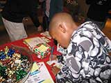 After gifts were chosen, the children were taken to add tags and bows to the wrapped presents. © Denise Gary