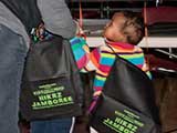 Debb helps two sisters put on their book bags. © Denise Gary